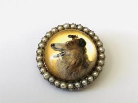 A late 19th century pearl and reverse crystal painted intaglio collie dog brooch